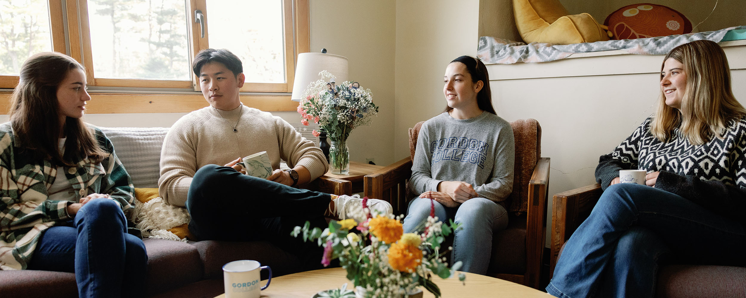 Students in an apartment talking through their bible study at their small group