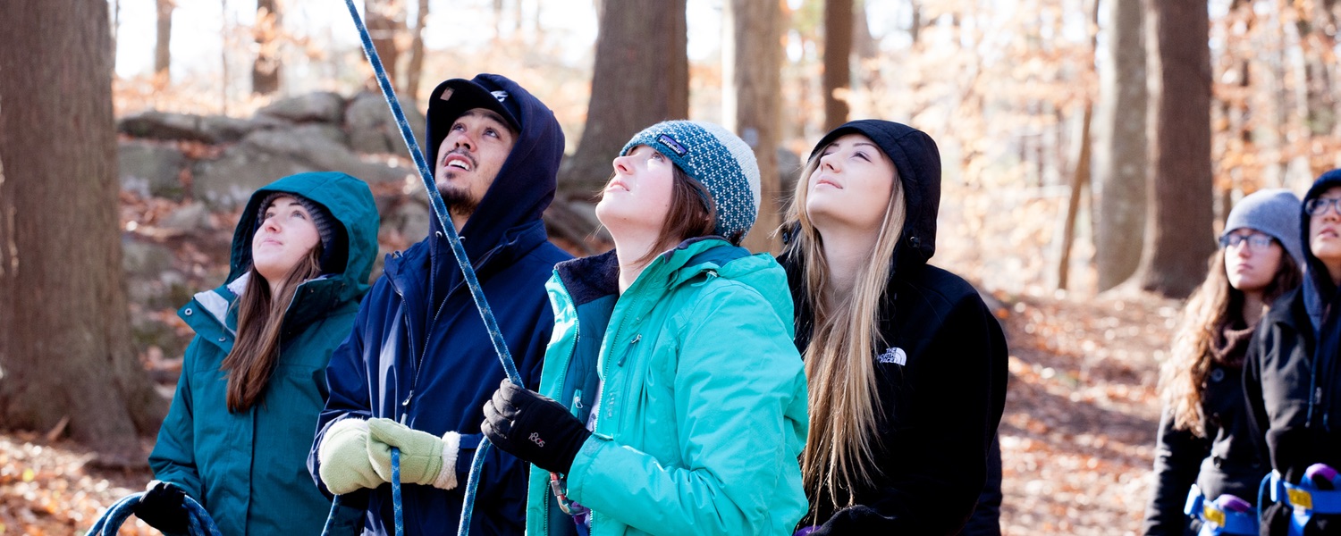 Students belaying for a climber