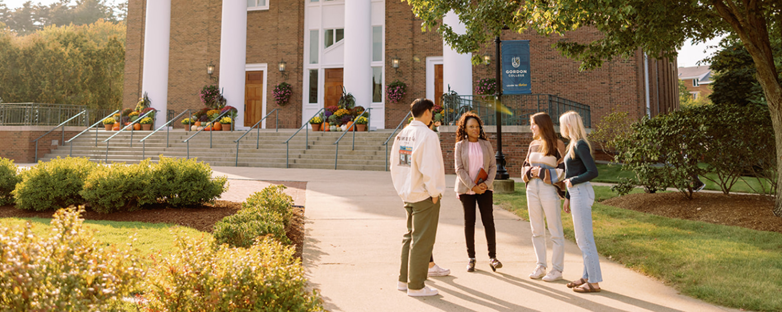 students talking to professor on campus 