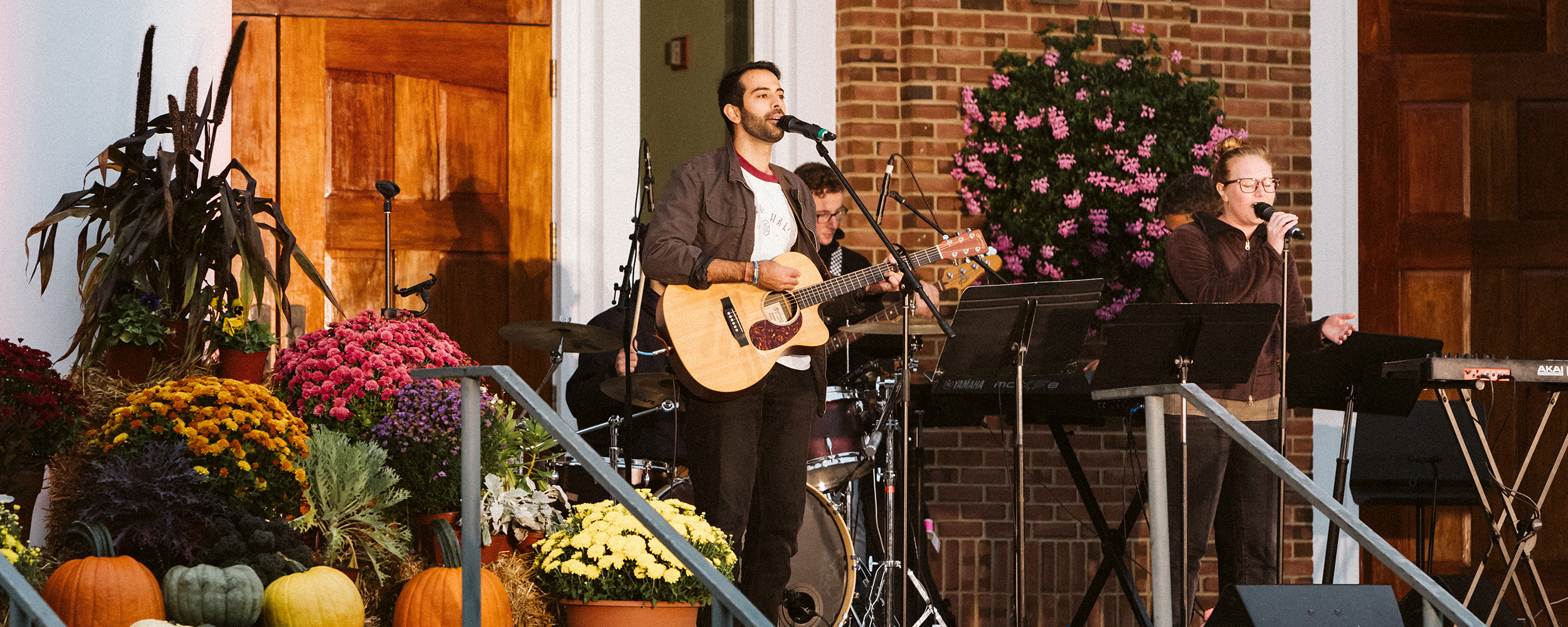 person playing guitar and singing at Gordon College chapel