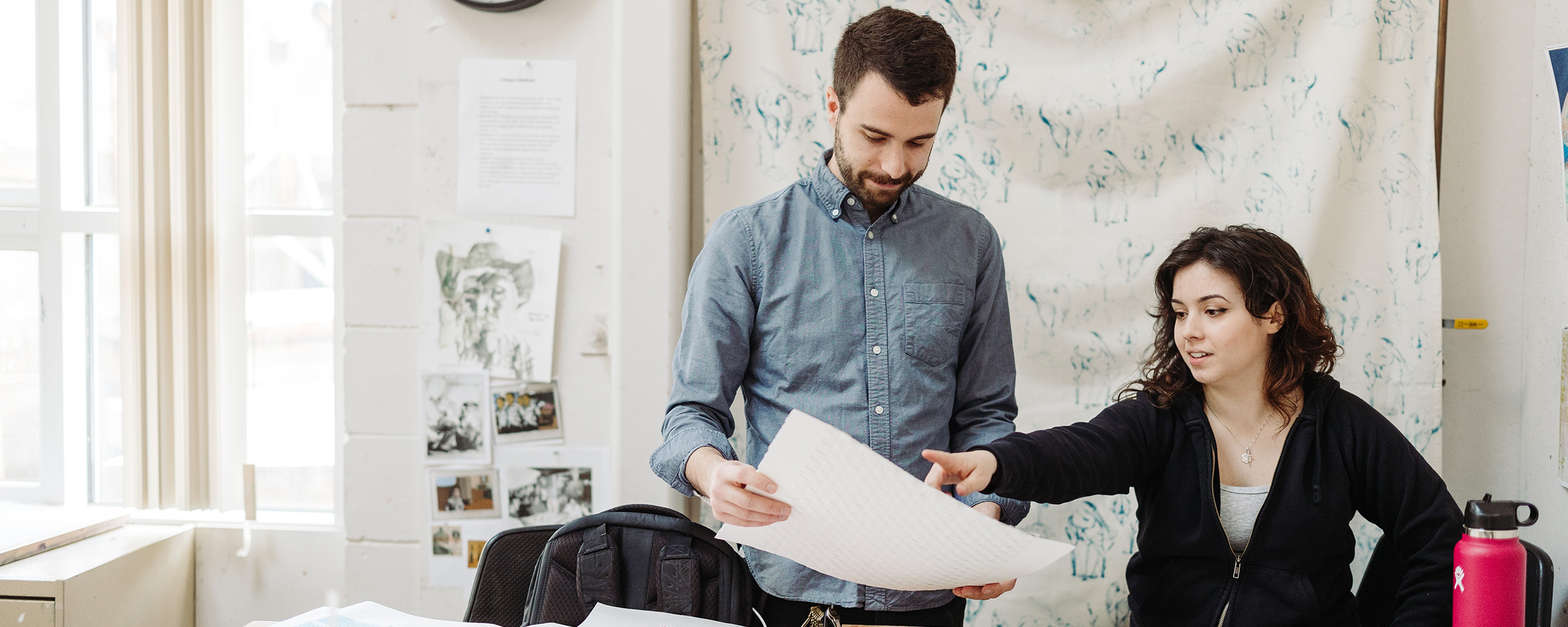 two students with graphic design studio minors looking at a design together in their Christian college classroom