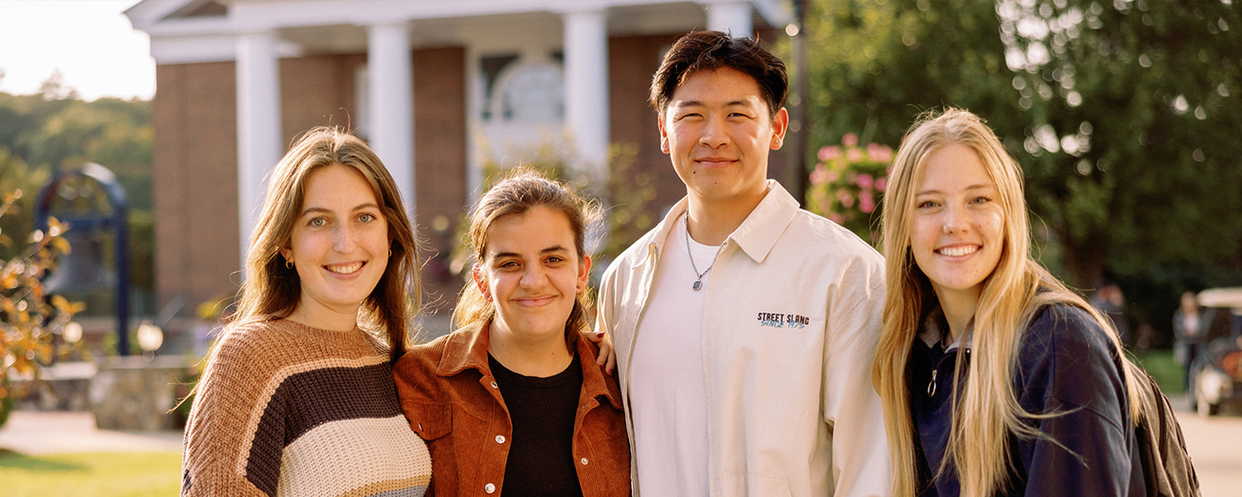 students smiling in front of chapel 