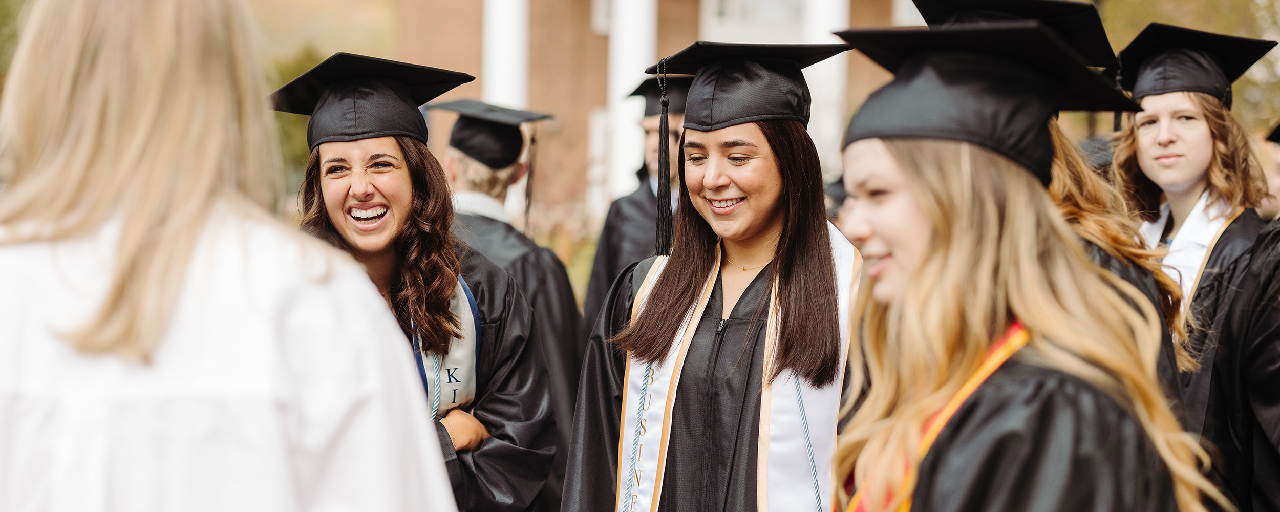 girls smiling with their friends at graduation