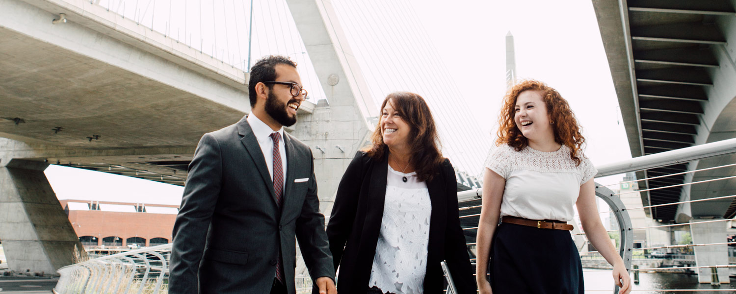 two Christian liberal arts college students and a staff member walking next to each other smiling and talking