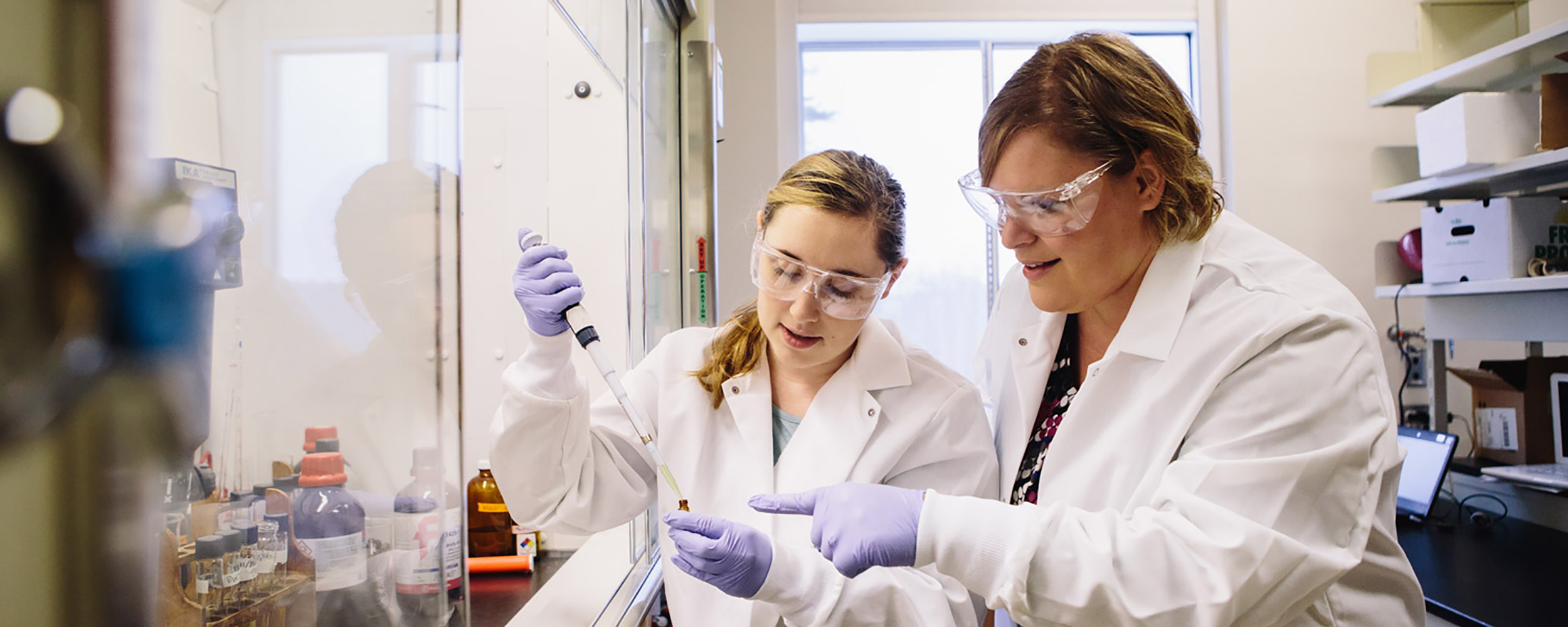 student and professor working with medicine cabinet