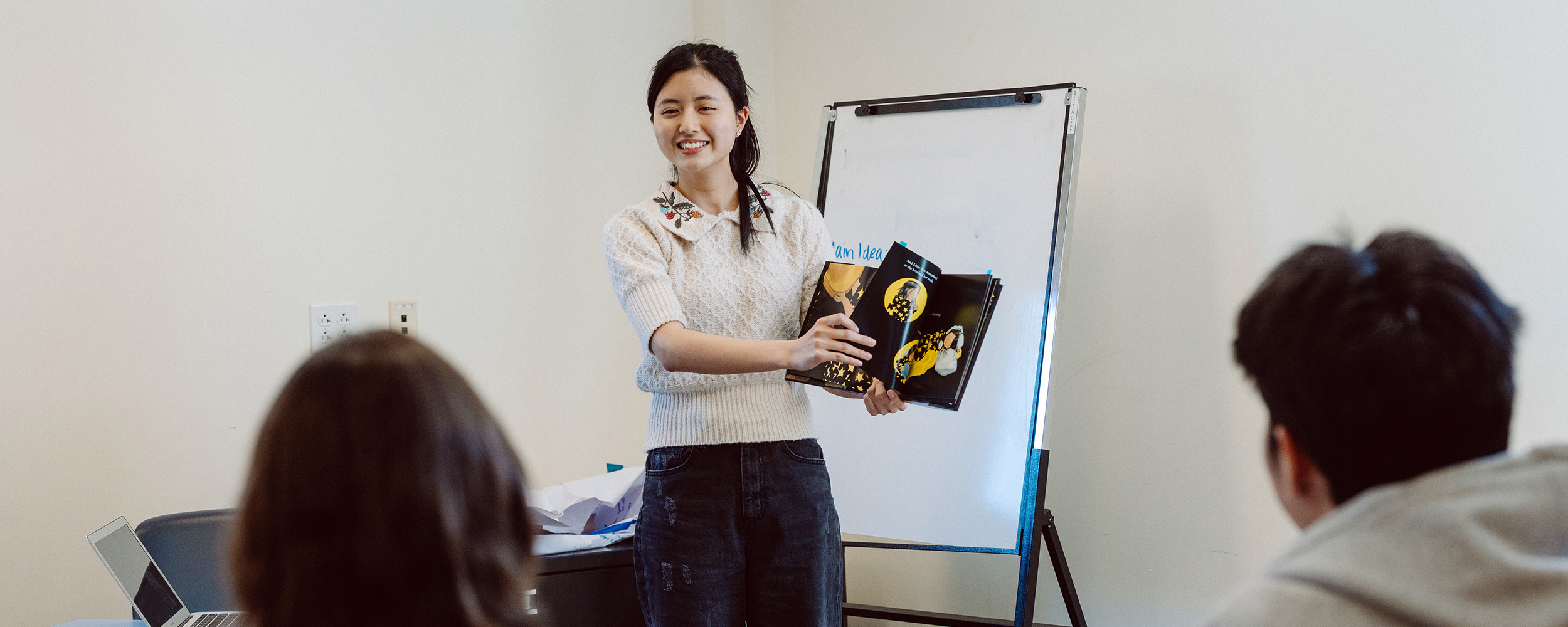 student teacher reading book to the class