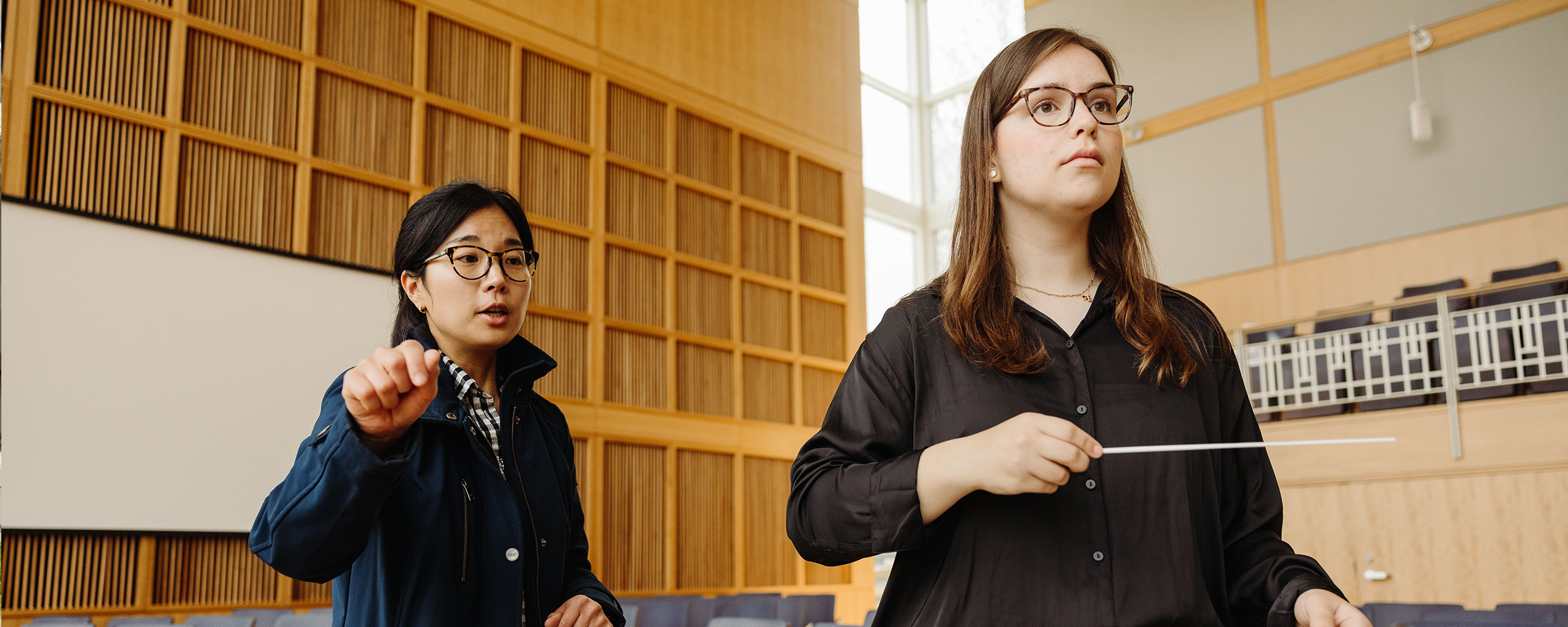 Two music education students at Gordon College learning and performing during class.