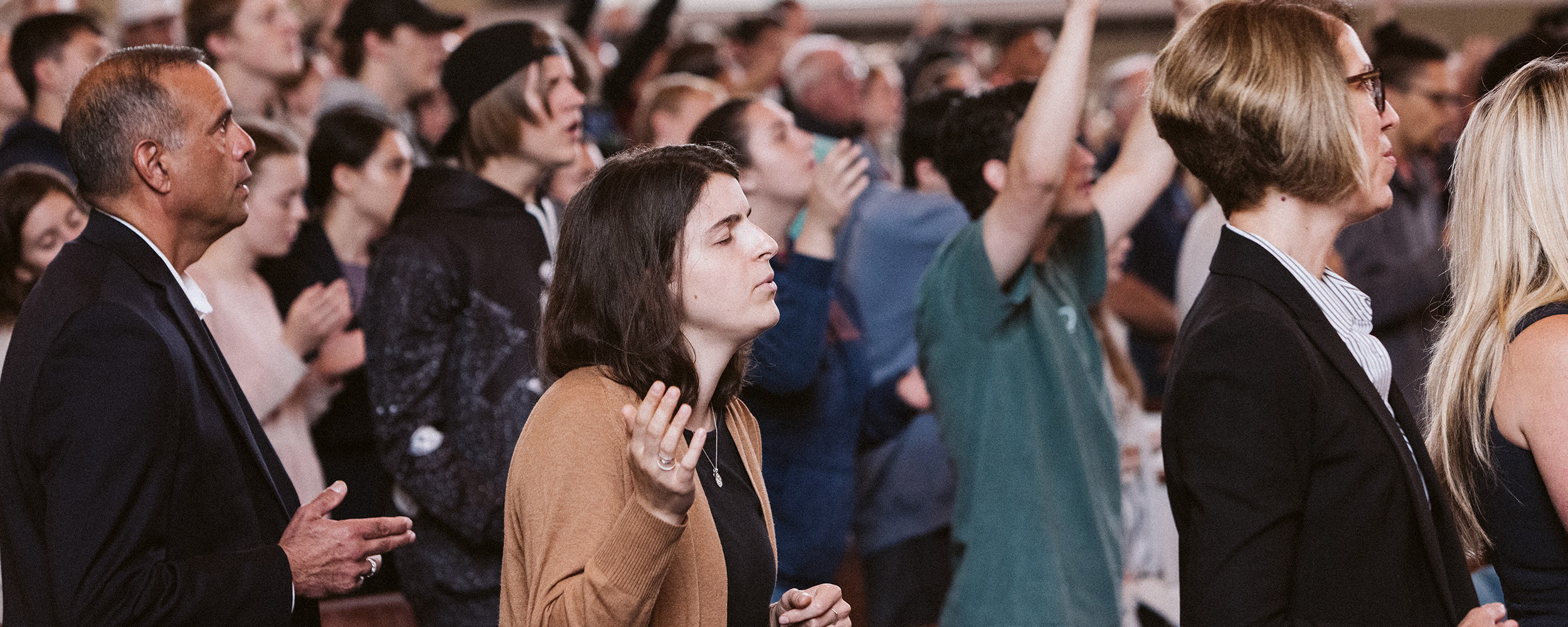 crowd of students and faculty at a college chapel worship service