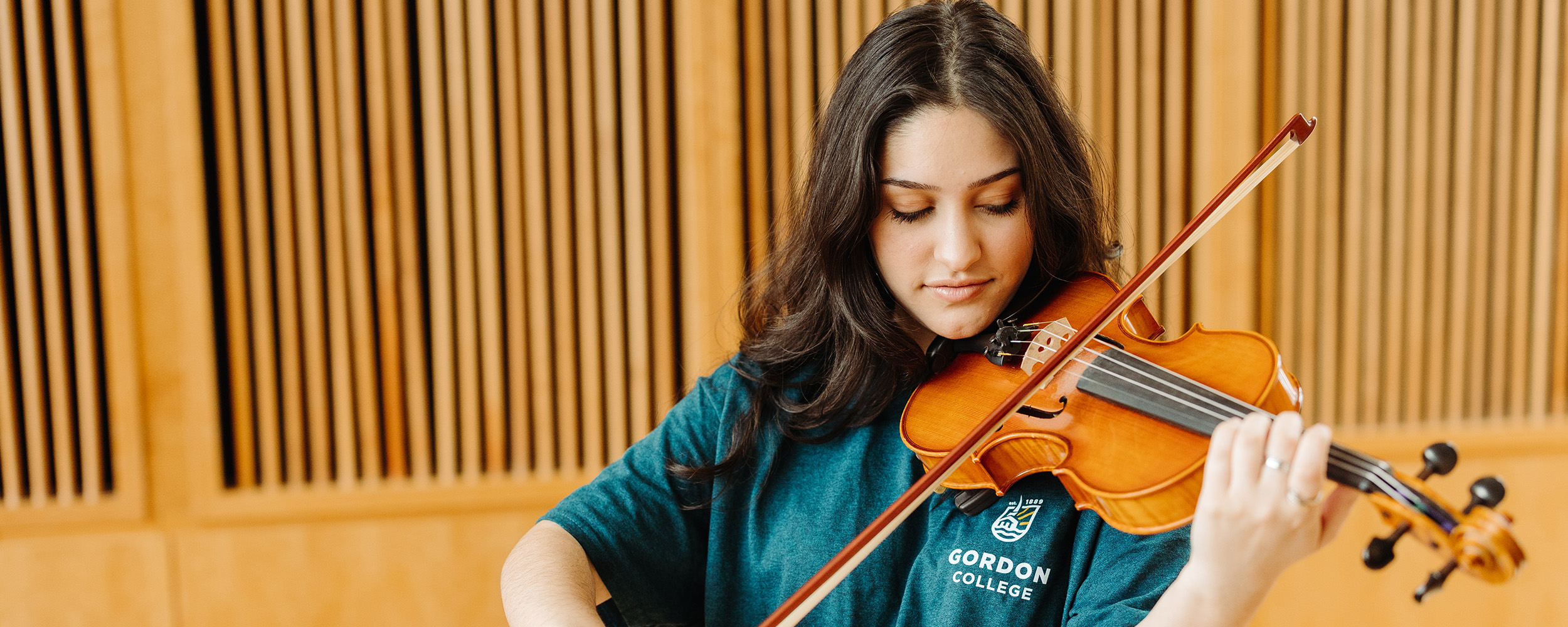 A student in the Music program at Gordon College playing the violin.