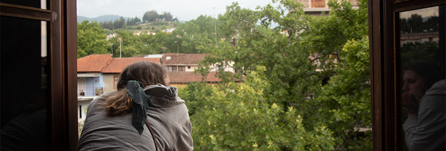 Student looking out over Greek city through a window