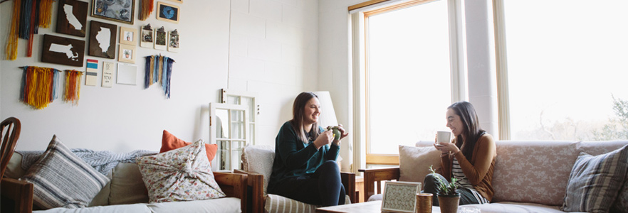 two female college students at Gordon College chatting in a living area of their dorm room