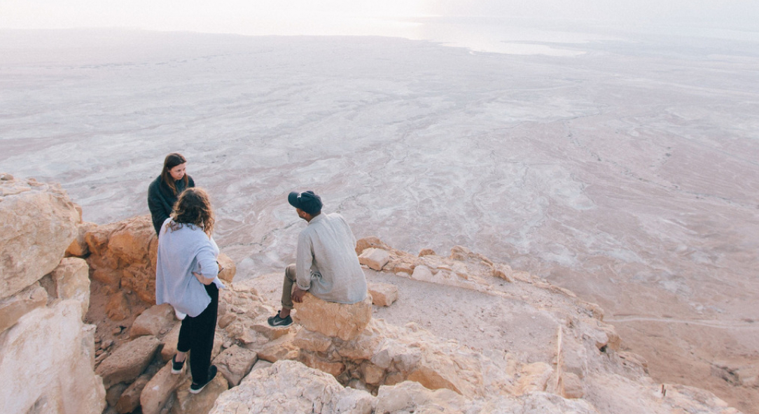 students sitting on a rock in Jerusalem